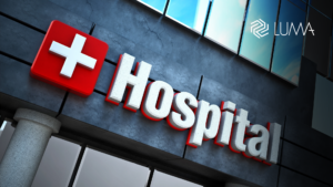 Monitor de signos vitales de hospital con interferencia digital roja, ilustrando un ataque de ransomware en el sector salud y la vulnerabilidad de equipos médicos.